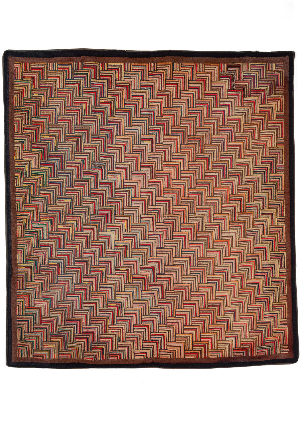 Antique North American square hook rug featuring a multicolored color palette, with an overall warm tone. The pattern is a variation of the classic log cabin design rendered in a way which it is reminiscent of the scales of a fish and that gives the piece added dimensionality. A thin dark brown border frames the whole.