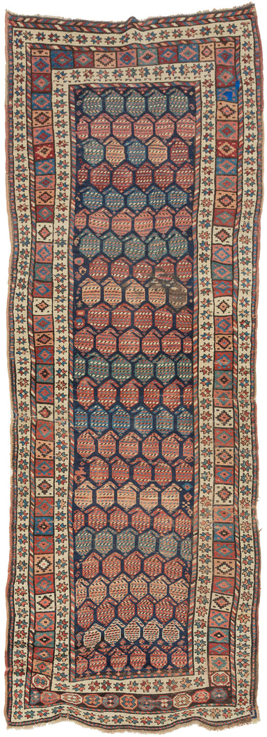 A wonderfully graphic Kurdish rug with a dark indigo field densely packed with rows of large botehs in coral, salmon, blue, green, ivory, and soft brown. Each boteh is filled with fine horizontal patterning, creating a lively surface of shifting color and texture.