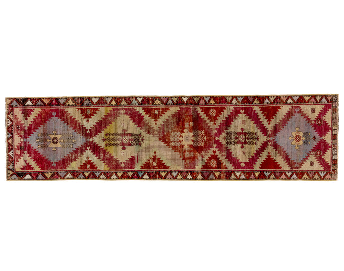 This Kirsehir runner was handwoven in central Anatolia during the 19th Century.</p> <p>This rug features a field of serrated diamonds flanked by sawtoothed triangles on a cochineal purple ground with additional tones of lavender, wheat and raspberry. This type often comes in prayer rug format and rarely in runner size.
