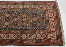 A finely woven Chi-Chi rug from the northeastern Caucasus, packed with the dense, jewel-like drawing for which the group is prized. The dark chocolate-brown field is organized in horizontal bands of stepped geometric medallions alternating with tightly worked floral and abstract devices in saturated cobalt blue, brick red, ivory, soft green, and apricot.