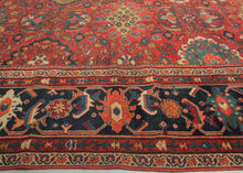 It features a dense and rhythmic allover pattern of palmettes, rosettes, and roving vinery set against a richly saturated madder red field.&nbsp;Lush floral clusters and shield-like medallions in blues, golds, ivory, and greens are symmetrically arrayed across the surface, producing a mesmerizing, layered composition.&nbsp;The deep indigo border is animated with bold palmettes and angular vine scrolls, grounding the exuberant interior with contrast and balance. This carpet’s large format and harmonious pale