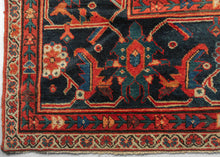 It features a dense and rhythmic allover pattern of palmettes, rosettes, and roving vinery set against a richly saturated madder red field.&nbsp;Lush floral clusters and shield-like medallions in blues, golds, ivory, and greens are symmetrically arrayed across the surface, producing a mesmerizing, layered composition.&nbsp;The deep indigo border is animated with bold palmettes and angular vine scrolls, grounding the exuberant interior with contrast and balance. This carpet’s large format and harmonious pale