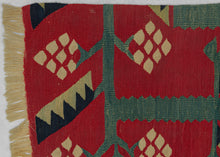 This Sarkoy kilim was in the Balkans during the 19th century.  It features a border fragment with a grape vine motif. An inner and outer border band is shown in light and dark blue. The vine is rendered in light blue with ivory grape bunches and two tone leaves of pistachio and navy on a rich red ground. Very old for type with great color and subject, would look lovely hung on a wall.