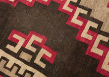 This Antique Navajo rug was handwoven in the Southwest USA during the first quarter of the 20th century.

This striking rug features jagged concentric lines vibrating from a small central diamond. The sharp angles and mottled tones of gray, brown, and red give the lines a dimensionality and they appear to float on the mottled gray inner field and variegated brown outer field. Framed by an inner dentil border and a red and brown serrated perimeter that has a flame like quality.
rare large size