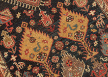 This stunning rug features a vertical medallion design on a deep indigo blue field. The field is filled with a fantastical world of various trees and plant forms surrounded by all types of animals. There are multiples types of birds including peacocks as well as two human figures near the bottom of the composition. The world is wonderfully painted with contrasting tones of reds, yellow, ivory, and aubergine. Lori rug tree of life