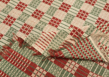 Overshot American Coverlet a grid of squares that utilize red and green wefts over an exposed white warp to create various patterns including stripes, diamonds and snowflakes. The grid is surrounded by a border of thin patterning on three sides. The top unbordered section is seamed with cloth indicating the original coverlet was likely longer.The addition of borders showcase the weaver's proficiency and skill. Fine weaving and wonderful contrast give this a crisp feel and eye dazzling visual effect.