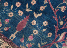 This Mohajeran Sarouk was handwoven during the first quarter of the 20th century.&nbsp;

It features an imaginative tree of life design of a small cypress flanked by two whimsically intersecting trees bearing palmette-shaped "fruit" on an inky blue ground. . Plush and well-executed these best-of-type Sarouks are referred to as "Mohajeran". Thinly framed like a painting with a generously spaced floral main border flanked by minor borders of polychrome circles;This classically patterned rug should