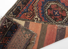 This&nbsp;Baluch rug was handwoven during the early 20th century in Afghanistan.

It features two octagonal Turkmen guls on a red ground and framed by a border of hourglass and cruciform shapes. Rich saturated tones and nice interplay between light and dark. It has original kilim ends on top and bottom that are each embellished with their own weft float pattern. This balisht has it's original kilim back still intact and which employs thick stripes of red, orange, brown and ivory.