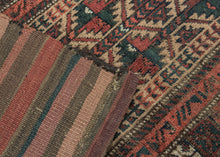 BALUCH BALISHT It features a geometric trellis motif in a variety of earthy reds and deep greens on a camel ground. The Baluch are masters of accomplishing a lot with a limited palette most often with the strategic use of white as us seen in the borders. This balisht has it's original kilim back still intact and which employs thick stripes of reds, blues, brown and purple.