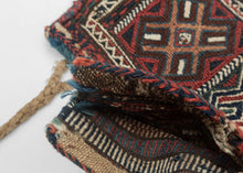 Luri namkadan saltbag soumak woven face with a pattern of bur-like protection symbols in two rows and on the neck of the bag. The top row breaks off to the left mid symbol while the bottom breaks off to the right mid bur giving the composition the illusion of movement. The pattern is simple yet complex with rich and saturated blues, reds, green, and apricot with chocolate brown and a bright white that really pops. The white is achieved by using cotton and can be seen on back of the bag 