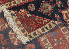 Karadagh It features a series of nested medallions that march down a rich abrashed indigo field. The medallions are rendered in blues, green, red, apricot and aubergine with geometric symbols and figures filling out the negative space. The pile is low and of lush high quality wool.
