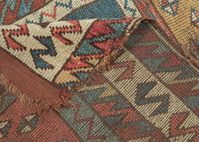 It features vertically stacked boxes, each filled with scattered diamonds across saturated grounds of color. The diamond motifs serve both as protective emblems and as a kind of visual chant, anchoring the eye while the overall composition moves with the spontaneity of Kurdish village life. The palette is classic and earthy: madder red, saffron gold, deep indigo, and teal, with ivory highlights animating the zigzag borders.