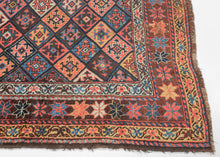 This vibrant rug showcases the bold geometry and saturated color that make these weavings among the most collectible of Kurdish works. It features the classic Jaff interlocking diamond pattern in bright, cheerful colors. The palette is exceptionally rich, with deep madder red, indigo blue, saffron yellow, ivory, and touches of soft green. Each diamond compartment has its own personality, yet the overall effect is one of harmony and movement. The star-filled borders frame the design with balance and complete