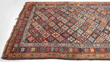 This vibrant rug showcases the bold geometry and saturated color that make these weavings among the most collectible of Kurdish works. It features the classic Jaff interlocking diamond pattern in bright, cheerful colors. The palette is exceptionally rich, with deep madder red, indigo blue, saffron yellow, ivory, and touches of soft green. Each diamond compartment has its own personality, yet the overall effect is one of harmony and movement. The star-filled borders frame the design with balance and complete