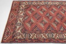 This Yomud Turkmen rug was handwoven during the early 20th century in Western Turkmenistan.

This finely balanced Yomud carpet features a repeating dyrnak-gul field in shades of plum, indigo, ivory, coral, apricot and sky blue. Each diamond-shaped motif radiates a strong tribal geometry, emblematic of Yomud weavings from the Caspian steppe.