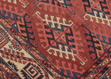 This Yomud Turkmen rug was handwoven during the early 20th century in Western Turkmenistan.

This finely balanced Yomud carpet features a repeating dyrnak-gul field in shades of plum, indigo, ivory, coral, apricot and sky blue. Each diamond-shaped motif radiates a strong tribal geometry, emblematic of Yomud weavings from the Caspian steppe.