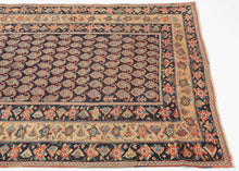 A beautifully composed Afshar rug featuring a classic allover boteh field, each sprouting motif rendered with crisp definition against a deep indigo (almost black) ground. The botehs are arranged in tightly organized rows, creating a shimmering, textile-within-textile effect that rewards close looking. Subtle shifts in dye tone animate the surface, giving the field a sense of depth and movement.

Framing the boteh lattice is a vibrant, floral border system of spiraling blossoms, stylized palmettes, and angu