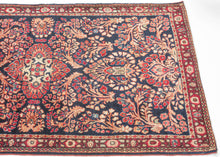 This finely woven Sarouk exemplifies the lush floral language that made the region’s carpets among the most sought-after of 1920s. Set against a deep midnight-blue ground, an intricate lattice of scrolling vines, palmettes, and rosettes unfolds with remarkable density and clarity, anchored by a subtle central medallion that gives structure to the otherwise allover composition.