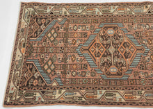 A lively small Hamadan with a geometric medallion composition set against a warm rose-brown field. Crisp ivory, turquoise, deep brown, and soft orange accents create strong contrast and rhythmic movement across the surface.