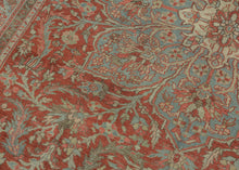 A commanding Heriz rug distinguished by a more ornate, curvilinear drawing than the classic, highly angular Heriz style. The richly saturated red field is centered by a large, radiating medallion with scrolling floral forms that lend fluidity and movement to the composition.