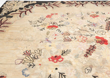 Large early–mid 20th century American hooked rug (8’8” x 11’10”) with a soft ivory floral field in muted pastels, framed by a bold charcoal border with red and cream scrolling vines; from a New Hampshire collection.