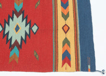 A bright contemporary Oaxacan flatwoven rug by Zapotec weavers from Teotitlán del Valle, Oaxaca. The design features a bold red field with a central stepped diamond medallion, flanked by arrow and diamond borders in blue, yellow, green, turquoise, orange, and red.