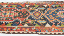 Bakhtiari Gabbeh runner from Southwest Persia with stepped medallions, geometric and stylized floral motifs in coral, indigo, teal, and ivory, arranged in a vertical layout with patterned borders.