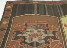 Vintage Kars kilim from eastern Turkey with three geometric medallions in brown and green tones, arranged within an open field with horizontal banding and framed by a border of small repeating diamond motifs.