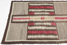 This exceptional vintage Navajo weaving is distinguished by its remarkably bold and unconventional composition. A dramatic abstracted butterfly or cruciform motif anchors the design, its rhythmic serrated forms creating a striking sense of movement while broad expanses of natural gray wool provide a calm, spacious counterpoint. The result is a textile that feels both deeply rooted in tradition and distinctly modern.