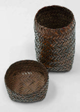 A finely made lidded basket attributed to the Kuba peoples of the Democratic Republic of the Congo, constructed from broad strips of plant fiber in a tightly worked herringbone plait.

The tall, compact form is animated by a bold chevron pattern that shifts direction across the surface, giving the basket a distinctly architectural quality. The fitted lid continues the same interlocking weave, creating a unified sculptural form when closed.