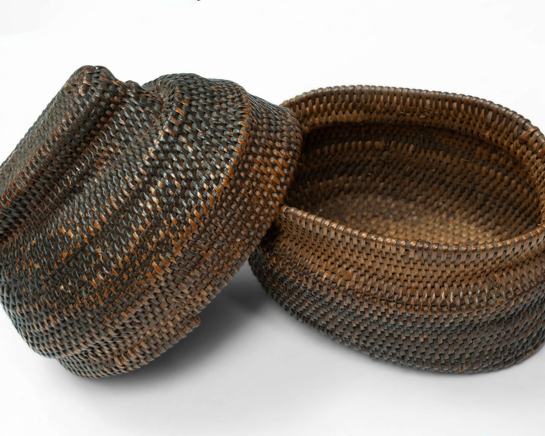 A finely made lidded basket attributed to the Kuba peoples of the Democratic Republic of the Congo, tightly plaited from raffia palm fiber and finished with a fitted cover and raised woven grip.