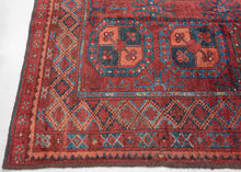 A handsome Ersari Turkmen carpet with a richly saturated madder-red field organized into rows of large octagonal guls, each quartered and filled with small floral devices. Between them, angular cruciform ornaments create a secondary lattice, giving the field an unusually energetic rhythm.