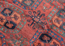 A handsome Ersari Turkmen carpet with a richly saturated madder-red field organized into rows of large octagonal guls, each quartered and filled with small floral devices. Between them, angular cruciform ornaments create a secondary lattice, giving the field an unusually energetic rhythm.