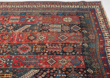 An exceptional Shekarlu rug with an unusually elaborate striped field, alternating saturated madder-red and deep indigo panels packed with an astonishing vocabulary of small motifs. Trees, rosettes, comb-like devices, lattices, geometric medallions, animals, and tiny human figures appear almost like a woven archive of tribal imagery, with scarcely an inch left unconsidered.