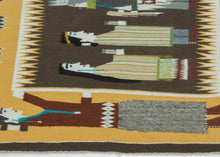A finely woven Yei Bi Chei pictorial by celebrated Diné weaver Della Woody Begay, depicting a ceremonial procession of masked figures associated with the Navajo Nightway tradition. The dancers are arranged in a rhythmic line between two larger attendant figures, set against a deep brown ground and framed by Woody’s particularly distinctive serrated, cloud-like border.
