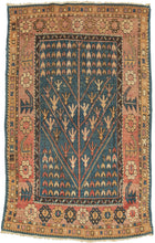 This rug was by Kurds during the first quarter of the 20th century.  It features an abstracted and directional tree of life motif on a cerulean ground. Framed by a main border that alternated between rosettes and serrated leaves on the sides but is composed solely of rosettes on the top and bottom.&nbsp;