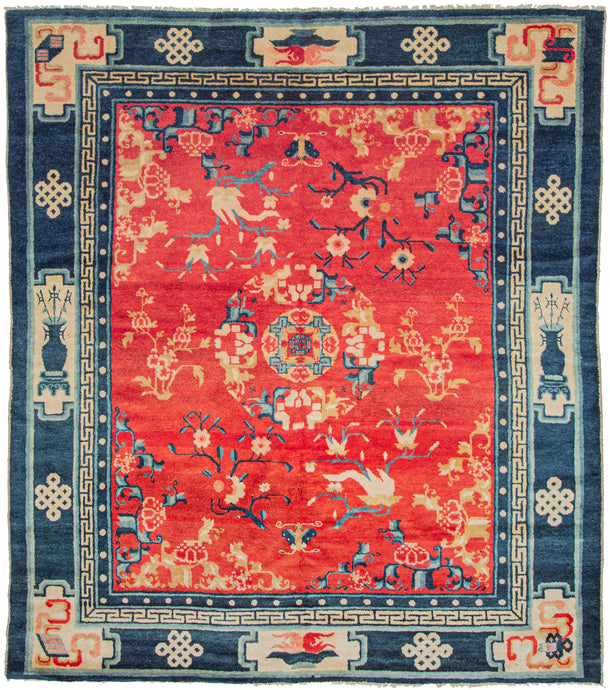 The main design is composed of a central mandala, encircled by flower branches and blossoms on a rich red ground. This red tone is very auspicious and often associated with prosperity. The main border design separated into cartouches that include and various auspicious symbols. Between each cartouche is an endless knot symbol. The minor borders feature the classic pearl motif and greek key motif.
