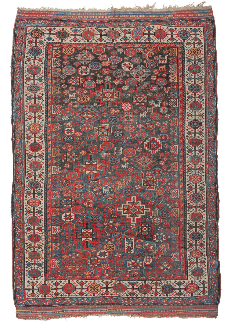 Antique Qashqai Shekarlu rug featuring a spectacular all-over field chock full of latch hooked polygons, rosettes, serrated combs, and various types of animals and protection symbols. Beautifully layered with haphazard spontaneity and free-flowing shifts in scale and rhythm yet still cohesive and engaging like well-improvised Jazz. It features captivating reds, soft blues, yellows, purplish-brown and bright ivory on a rare greenish-blue ground.