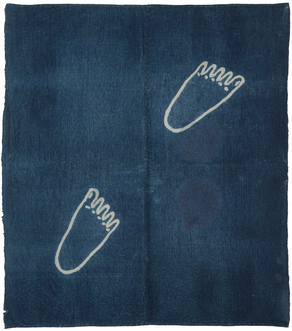 Japanese indigo-dyed ashi-negui towel with two stylized foot motifs created using rice paste resist on a deep blue ground.