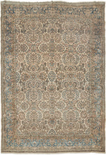 Kerman rug handwoven during the second quarter of the 20th century.  It features an allover design of bouquets and floral sprays in soft tones of pinks, blues and browns on a creamy ivory ground. It is framed by a perfectly reconciled border of blossoming flowers on a light blue ground. Precisely rendered to great visual effect with a soft palette for an understated yet elegant feel.