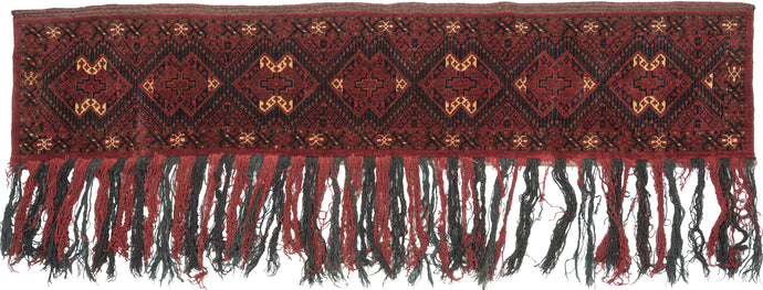 This trapping was handwoven by Ersari Turkmen around Middle Amu Darya in Central Asia during the 20th Century. The Ersari weavings from this region in this style are often referred to as Beshir. Features ikat-inspired güls in earthy reds, ivory, yellow, and navy. wonderful hanging fringe which alternates between madder red and deep indigo. Likely made to hang on the wall or for use on a pack animal. The top is finished with lovely brocaded embellishment.