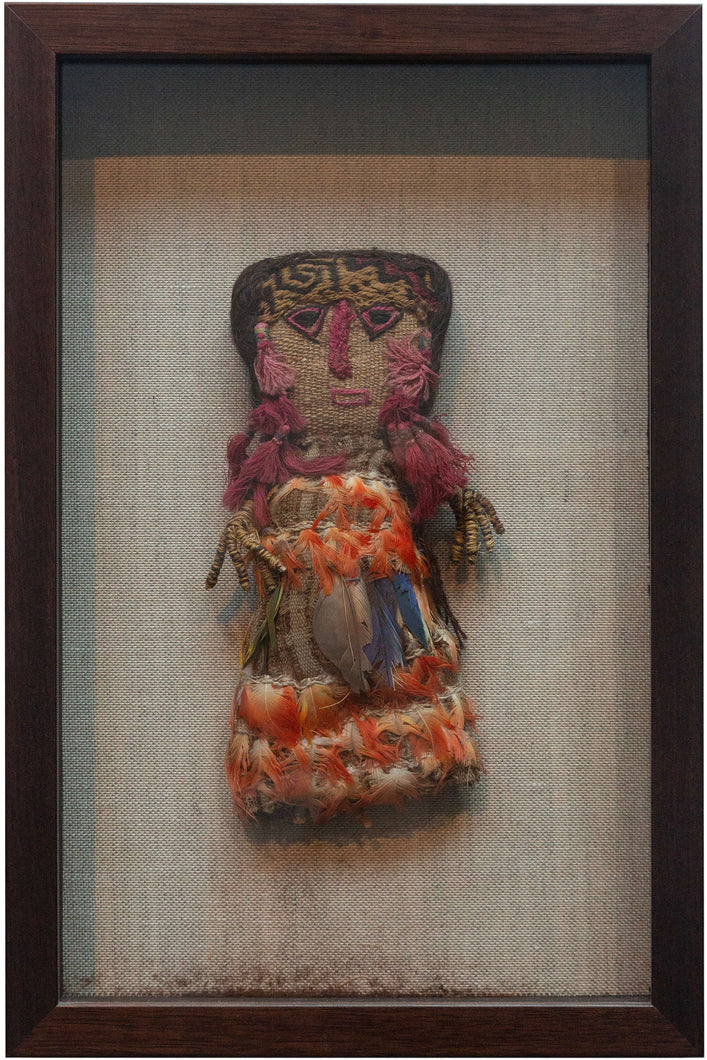 Chancay dolls that often have a simple fabric or burlap face with woven or embroidered facial features. This piece features wonderful cochineal dyed tassels and inlcudes blue and orange macaw feathers.