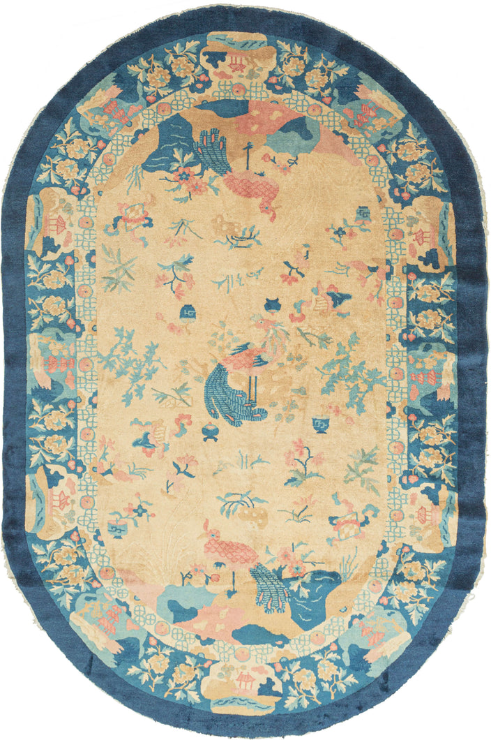 Art Deco handwoven in Tientsin, China This oval-shaped rug features a variety of floral forms and three birds on an unusual sand colored ground. The birds may represent the story of the Fenghuang which began as two different birds, the male Feng and the female Huang which eventually merged to one bird can represent harmony and everlasting love. Framed by a main border that alternates between floral forms and tiered structures with an inner border of ying-yang 