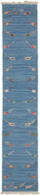 Blue tulip motif kilim runner featuring a repetition of delicate polychrome tulips around a blue field. The tulips are finely woven of handspun wool in naturally dyed tones of yellow, green, brown, red, and pink and float upon an indigo field. The indigo background vibrates with each natural variation giving it a simple and straightforward presence, as well as a special feeling.