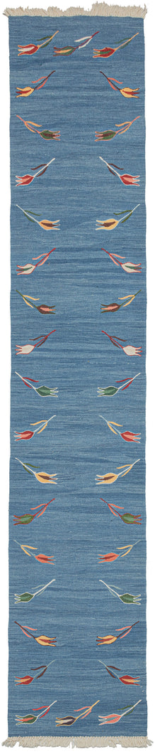 Blue tulip motif kilim runner featuring a repetition of delicate polychrome tulips around a blue field. The tulips are finely woven of handspun wool in naturally dyed tones of yellow, green, brown, red, and pink and float upon an indigo field. The indigo background vibrates with each natural variation giving it a simple and straightforward presence, as well as a special feeling.