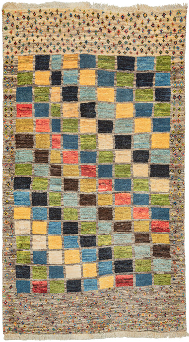 Contemporary Gabbeh. It features alternating stepped rows of polychrome squares that travel on the diagonal creating a geometric rainbow effect. The selection of red, yellow, green, brown and mutliple blues is energetic and calming at the same time. A perimeter border of polychrome diamonds is thinner on the sides longer on the bottom. The pile is densely woven, making this a plush rug.