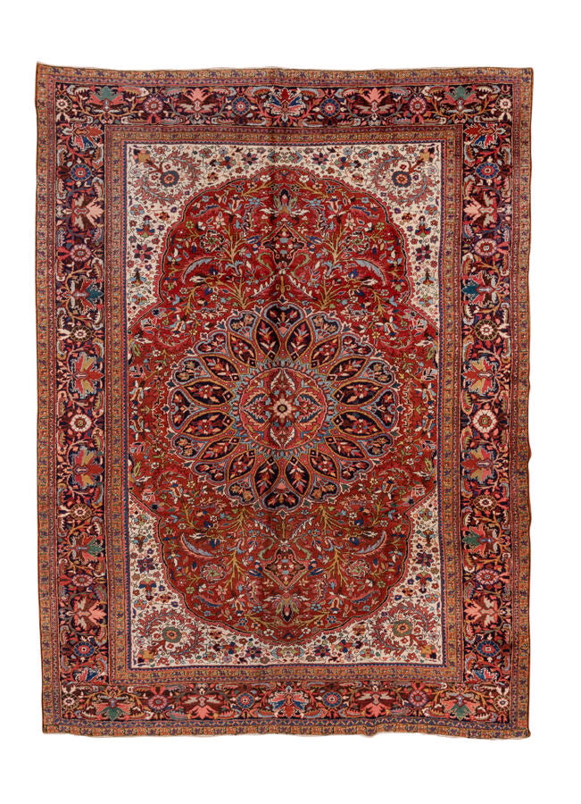 A bold and characterful Heriz carpet with a classic architectural composition anchored by a powerful central medallion. Angular vinery and serrated leaf forms radiate outward across a richly saturated madder-red field, surrounded by dynamic drawing that balances tribal energy with the structured geometry typical of the Heriz weaving tradition.