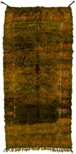 This Ait Ouaouzguite rug was woven south of the High Atlas mountains of Morocco during the 20th century.  This lively  on a green ground. The design is almost completely obscured by a thin shaggy pelt like pile. Moving the pile around unveils hidden parts of the design. A very fun and distinctive piece. Was likely intended to be used "upside down".  The green is reminiscent of a naturally nuanced jadestone and the wool has the hand of a soft sheepskin.