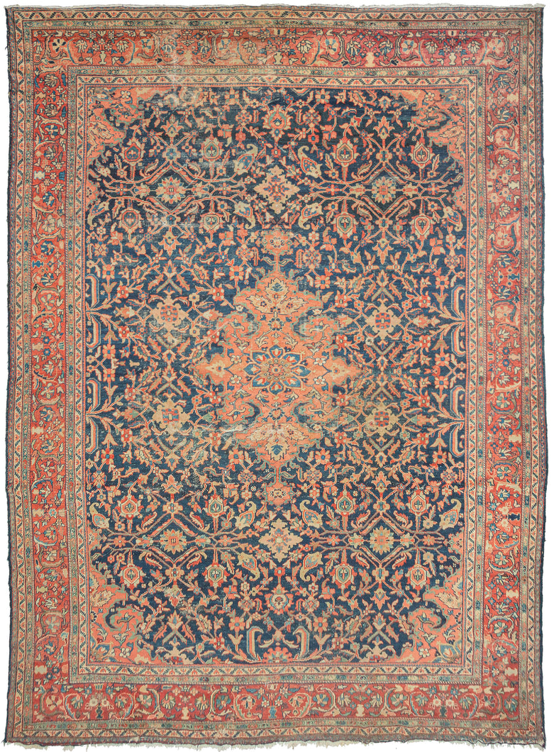 Large antique blue mahal rug featuring a central medallion and four cornices rendered in a lovely coral tone on a blue field of scrolling vines with palmettes in blues, red, seafoam, and gold. The main border is composed of scrolling vine work on a soft crimson ground. The wear to the foundation adds a little edge to the ornate patterning.