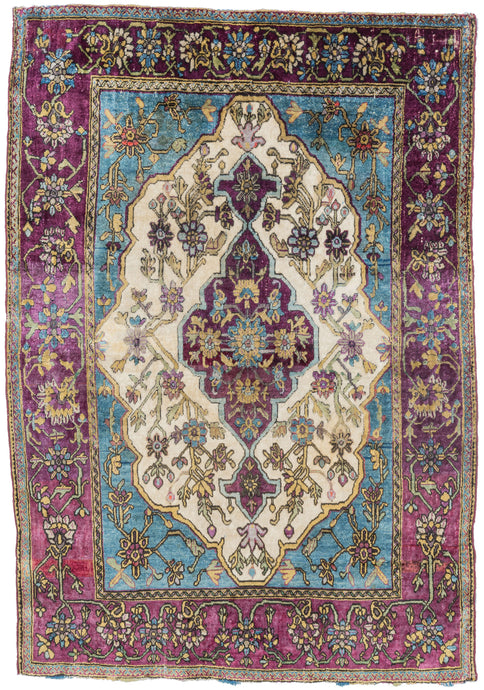 silk motashem kashan well balanced and energetic piece features a purple central medallion on a bright white ground surrounded by icy blue cornices and framed by a purple ground border. The blues and purples dyes are hallmarks of the famous atelier of Motashem as are the purple selvedges.The silk pile magnifies the top tier tones and contrast of this finely woven rug.The very precise and dense weave makes this rug exceptionally fine. Highly collectible and a delectable feast for both sight and touch